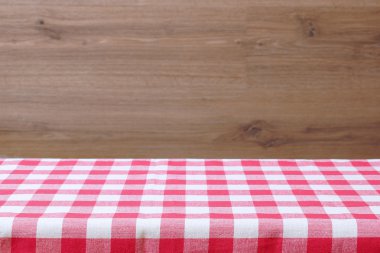 Boş bir tablo ile bir kırmızı kareli masa örtüsü. Ahşap arka plan.