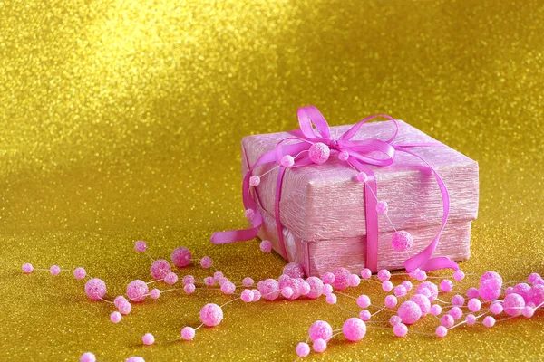 Sarı zemin üzerine hediye ile pembe kutu