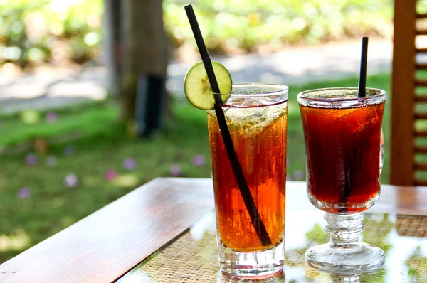 Refrescante chá gelado de limão e chá preto no jardim — Fotografia de Stock