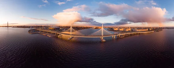 Letecký panoramatický výhled na večer St. Petersburg a Cable-stay most přes Petrovsky fairway. Západní vysokorychlostní průměr WHSD při západu slunce. Moderní dálnice podél řeky Nevy v letním dni. Rusko. Stock Snímky