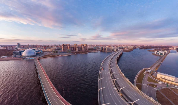 Luchtfoto Panoramisch uitzicht op de avond St. Petersburg en Cable-stayed brug over Petrovsky fairway. Westelijke hogesnelheidsdiameter WHSD bij zonsondergang. Moderne snelweg langs de Neva rivier in een zomerse dag. Rusland. Stockafbeelding