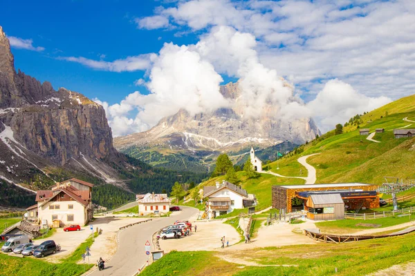 Utsikt över Passo Selva di Val Gardena med Cappella di San Maurizio vitt kapell, Hotell och parkering bil med berg Langkofel i bakgrunden. Dolomiti, Trentino Alto Adige, Dolomitalperna, Italien — Stockfoto