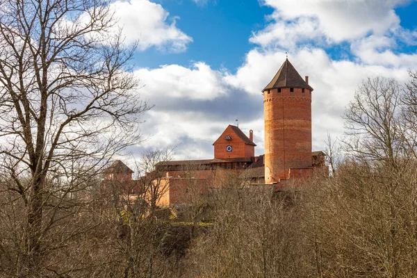 Uitzicht op het Turaida kasteel en de rivier Gauja bij zonsondergang in Sigulda, Letland. Gouden herfst met sinaasappelbos en rivier bij het kasteel, Toeristische plaats. — Stockfoto