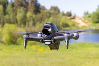 Moskova, 31 Mayıs 2021: Yeni bir DJI FPV insansız hava aracı beckground 'daki çimlerin üzerinde güneşli bir günde uçuyor. Üst Görüş. Dijital 4K ile Başsız Quadcopter 60 fps Hasselblad Kamera ve Uzaktan Kumanda