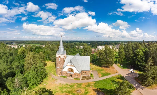 Aerial panoramic view to old lutheran church kirk Ryaysyalya designed by architect Joseph Stenback in style of Finnish romanticism, Art Nouveau in sunny summer day. Melnikovo, Leningrad region, Russia — Stock Photo, Image