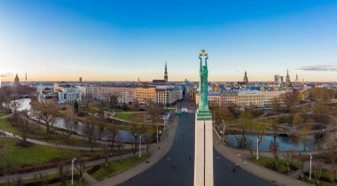 Sonbahar gündoğumunda arka planda eski bir kasabayla birlikte özgürlük anıtına muhteşem bir hava panoramik görünümü. Milda, özgürlük heykeli şehrin üzerinde üç altın yıldız tutuyor. Riga, Letonya, Avrupa.