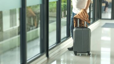 İş adamı gezgini havaalanında bavul taşıyor. İş seyahati. Uluslararası havaalanında. Tatil için terminal kapısına taşınıyor..