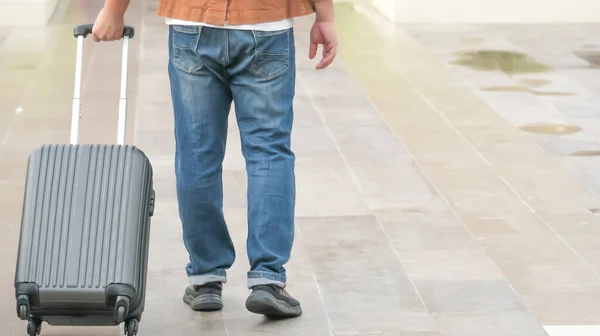 İş adamı gezgini havaalanında bavul taşıyor. İş seyahati. Uluslararası havaalanında. Tatil için terminal kapısına taşınıyor..