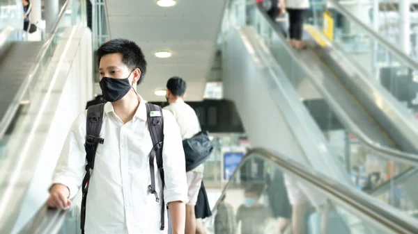 Man with luggage in airport terminal. Social distancing, International airport, on holiday, Corona virus, passenger wearing protective mask, after Covid-19, outbreak, Finding solitude