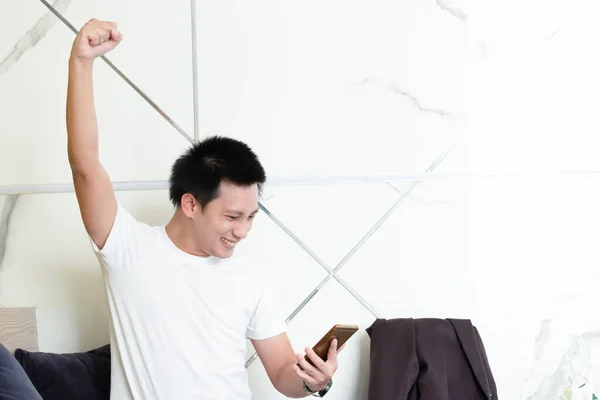 Successful professional casual man gesturing and checking cellphone messages,  Entrepreneur enjoys success in job. portrait of asian businessman.