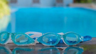 Image of swimming pool, goggles or Glasses for diving on the edge of a summer pool. No people, Holiday and vacation concept.