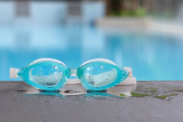 Image of swimming pool, goggles or Glasses for diving on the edge of a summer pool. No people, Holiday and vacation concept.