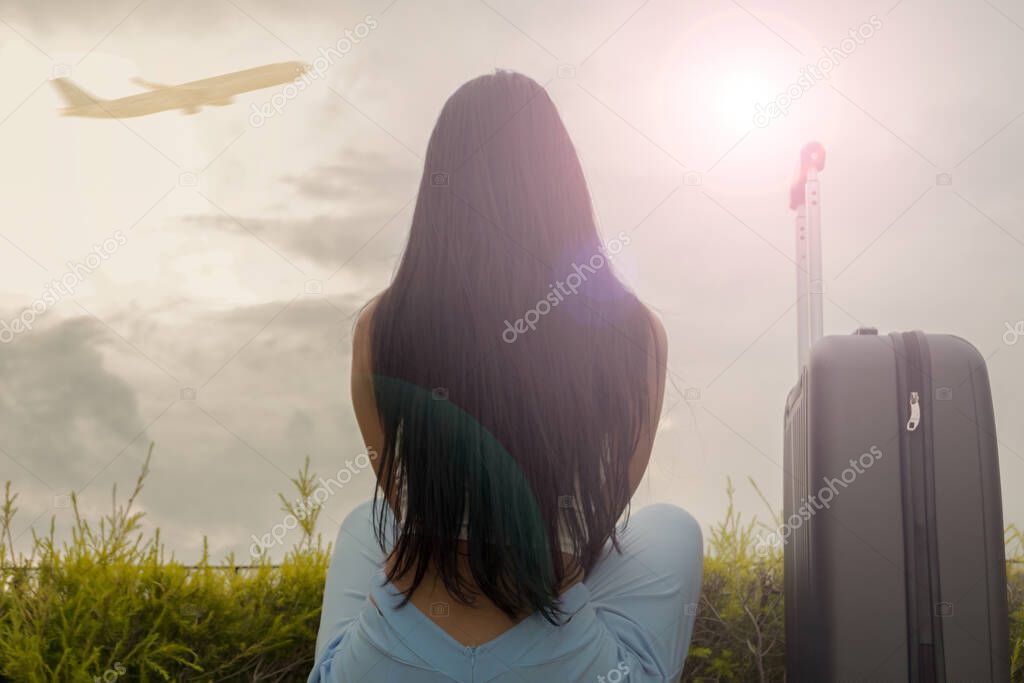 asian woman teenager sitting with luggage suitcase and backpack for travel in vacation summer relaxing time, while Watch the sunrise or sunset on holiday.