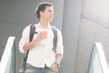 Genç Asyalı gezgin gezgin, seyahat konsepti, havaalanında gezen şehir işadamı. Takım elbiseli ve omuz çantalı sıradan bir Asyalı. uçak konseptine göre seyahat. 