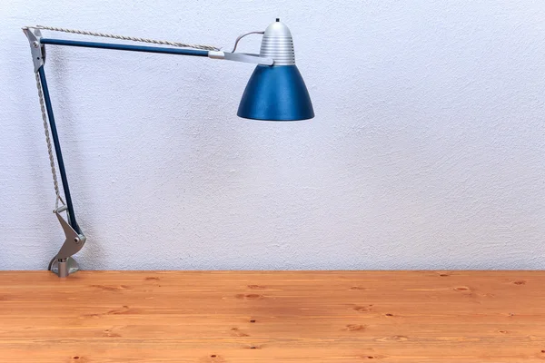 Lâmpada de mesa em uma mesa de madeira, contra um fundo de paredes texturizadas Fotografia De Stock