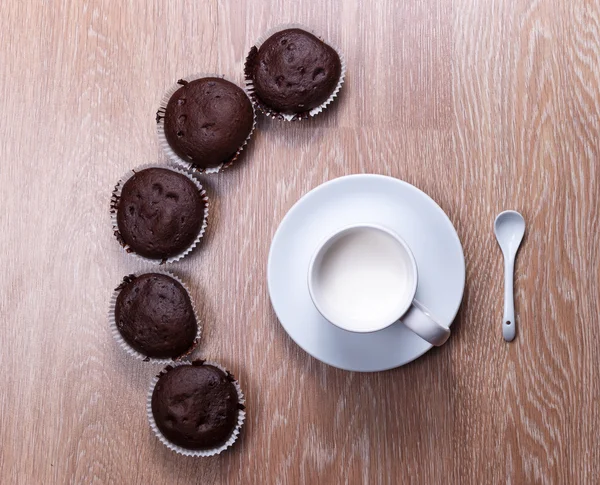 Plusieurs muffins et une tasse de lait dans un avion — Photo