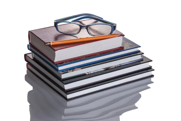 Stoh knih. Horní brýle a tužka. Stock Obrázky