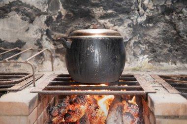 Kızgın ateşte eritilmiş demir tencere. Metal bir kazanda yemek ateşte pişirilir. Doğada yemek pişirmek. Ormanda güneşli bir yaz gününde piknik için dışarıda yemek yemek..