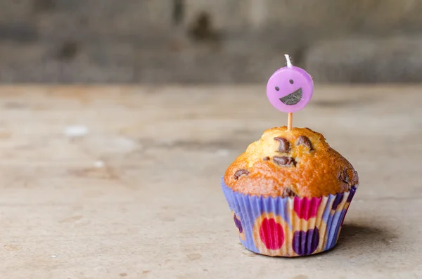 Cupcake aux pépites de chocolat et bougie souriante . — Photo