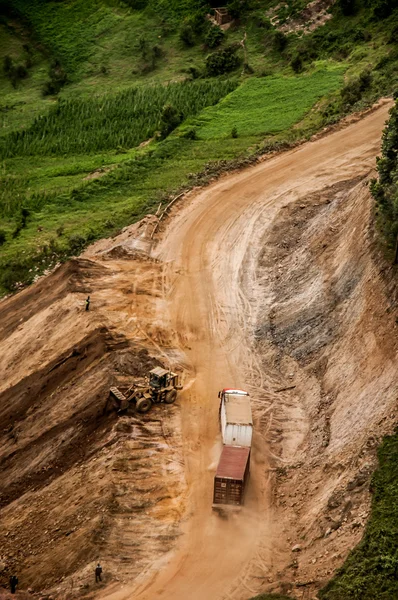 Truck and trailer on gravel road by mountain pass. — Stock Photo, Image