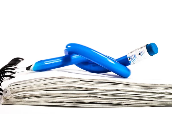 Blue Pencil, tied in a knot, on a small notebook. — Stock Photo, Image
