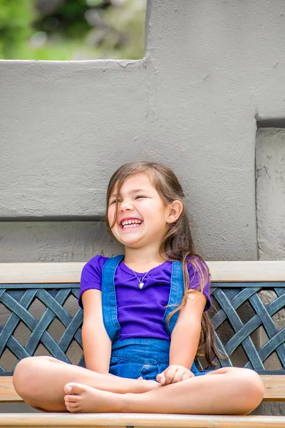Petite fille sur banc extérieur — Photo