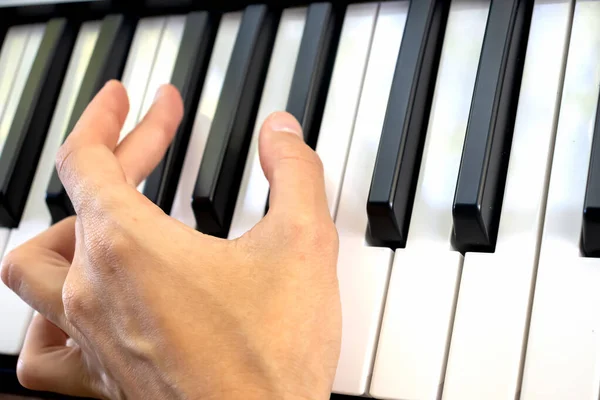 Fingers play chords on piano keys playing synthesizer pianist music hobby.