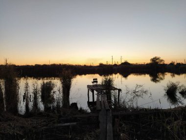 Akşamları gökyüzü yansıyan kırsal nehir, balık tutma yeri, arka plan ışığı
