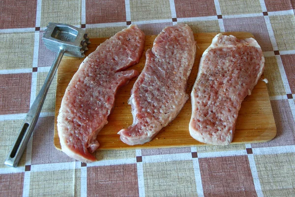 Drei Rohe Schweinekoteletts Mit Gewürzen Und Einem Hammer Auf Dem — Stockfoto