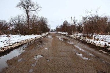 Kırsalda delikleri olan eski kötü asfalt yol.