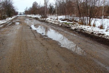 Kırsalda delikleri olan eski kötü asfalt yol.