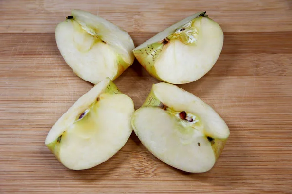 Four pieces of apple on the wooden background