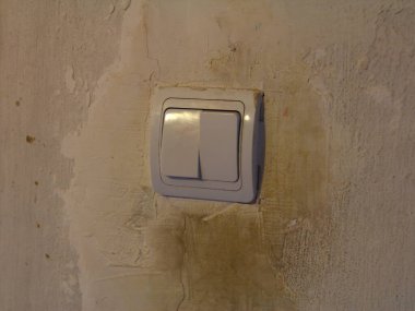 Kirli beyaz ışık düğmesi kirli beyaz duvar arka planında kirli el izleri