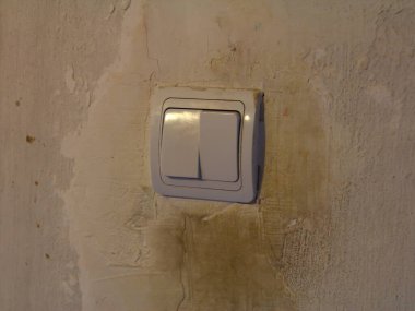 Kirli beyaz ışık düğmesi kirli beyaz duvar arka planında kirli el izleri