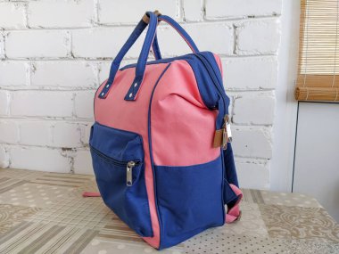 Mavi ve pembe sırt çantası masada, izole edilmiş.