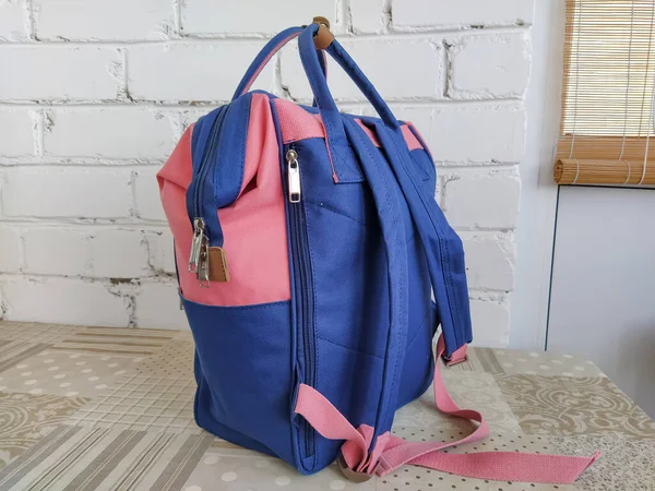 Blue and pink backpack is on the table, isolated