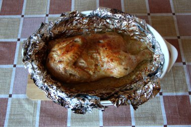 Baharatlı folyoda pişmiş yarım tavuk.