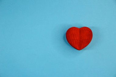 Kırmızı kadife kutu mavi arka planda bir kalp şeklinde, boşluğu kopyala