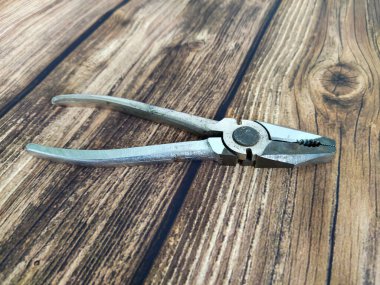 Çelik pense ahşap bir masada.