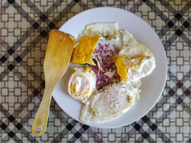 Bir tabakta üç yumurtadan kızarmış yumurta.