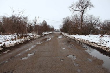 Kırsalda delikleri olan eski kötü asfalt yol.