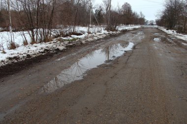 Kırsalda delikleri olan eski kötü asfalt yol.