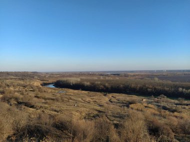 Sonbahar vadisinde nehir ve ağaçlar mavi gökyüzüne karşı