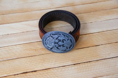 Ahşap arka planda deri kovboy kemeri.