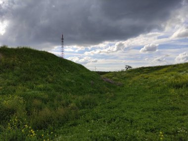 Bulutlu gölgeleri ve iletişim kulesi olan güzel bir dağ çayırı.