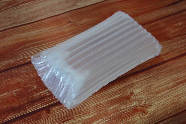 Ahşap arka planda plastik şişme hava geçirmez ambalaj