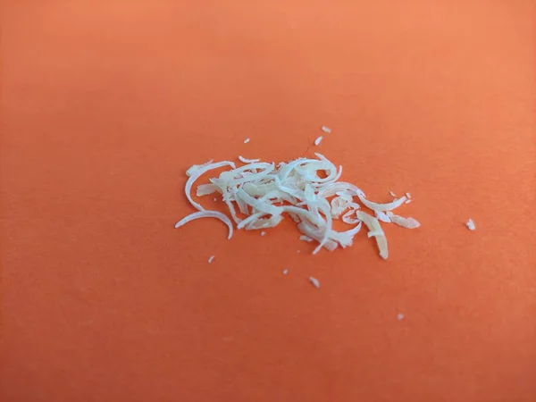 Clipped human nails on the orange background