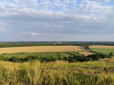 Tarım alanları, gökyüzü bulutları, tepenin manzarası