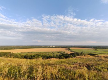 Tarım alanları, gökyüzü bulutları, tepenin manzarası