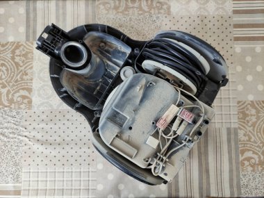 Parçalanmış elektrik süpürgesi bir masada.